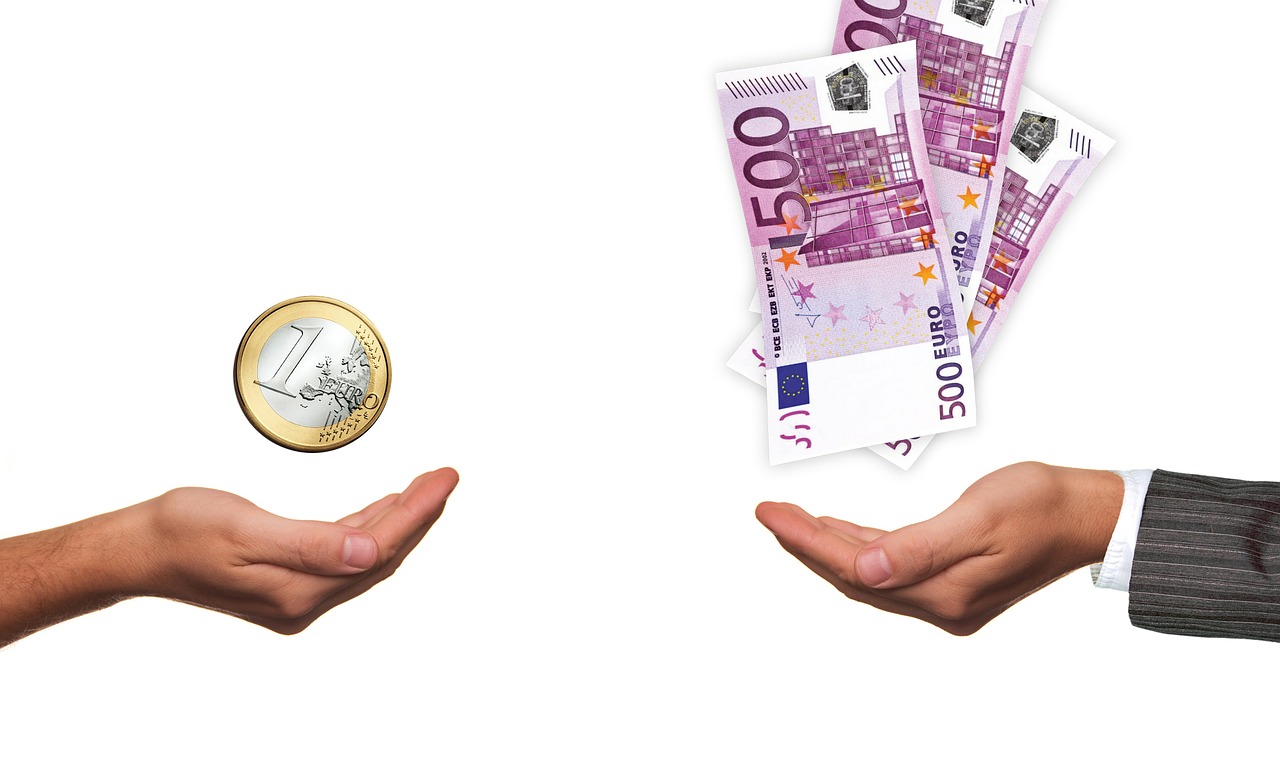 Zwei Hände einmal mit einem Euro in der anderen fünfhundert Euroscheine