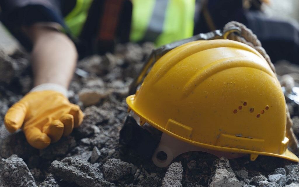 Arbeiter und Helm am Boden
