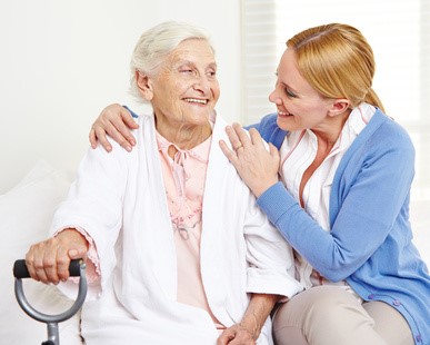 Pflegerin spricht einfühlsam mit Seniorin